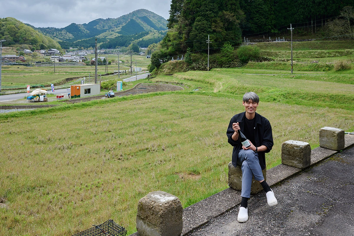 蔵の前の自作田を背景に倉本隆司さん
